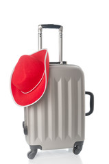 Travel bag and red hat on white background