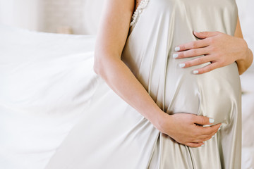 pregnant girl holding her belly with her hands