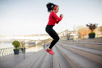 Papier Peint photo autocollant Jogging Young woman jumping outdoor