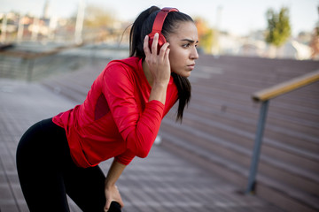 Pretty young woman takes a break after running