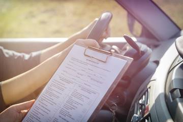 Examiner filling in driver's license road test form