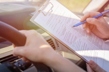 Examiner filling in driver's license road test form