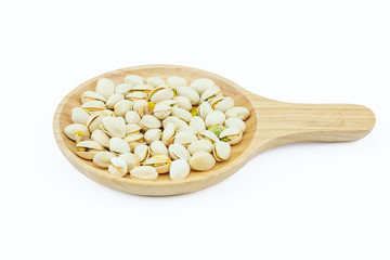 Salted pistachio nuts on wooden plate isolated on a white background