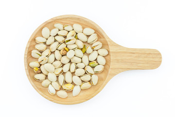 Salted pistachio nuts on wooden plate isolated on a white background