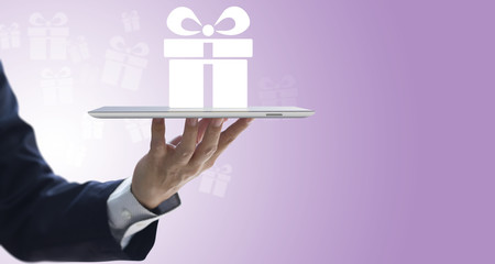 Butler holding a tablet serving a gift box to customers in concept of convenience online delivery with copy space. Isolated on white-purple gradient background.