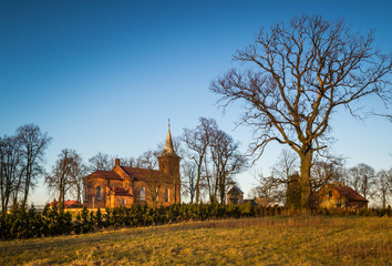Zabytkowy kościół na wzgórzu oświetlony zachodzący słońcem w miejscowości Górka Pabianicka, Polska © Senatorek