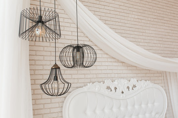 Wire black design ceiling luster hanging in bedroom. Loft interior details