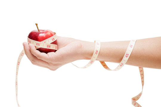 apple bind with measuring tape on hand isolated on white background, diet concept