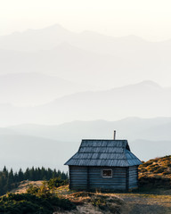 Mountain cabin during sunrise. Alone house on spring meadow. Located place: Carpathians, Ukraine, Europe