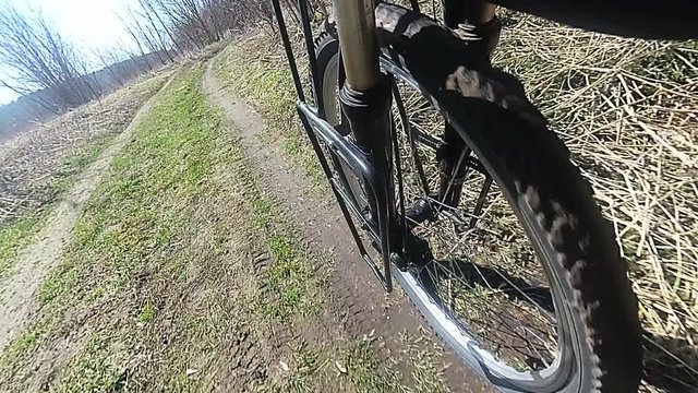 Wheel of  bicycle  with tyre goes on  dirt road. Slow motion. 

