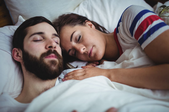Couple sleeping together on bed