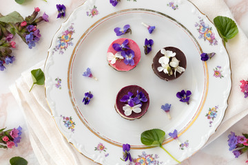 Raw vegan desserts with fresh violet and lungwort flowers