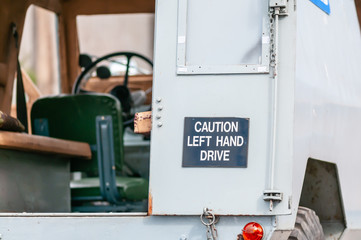 Sign on the back of an old Police Armoured Landrover as used by the RUC in Northern Ireland, warning following motorists that it is left-hand drive.