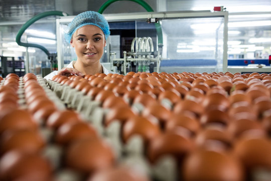 Portrait of female staff examine eggs