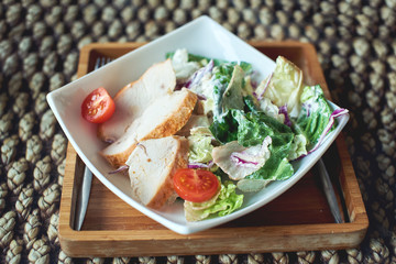 Caesar salad is on the plate in a restaurant.