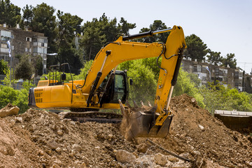 yellow excavator machine with risen boom construction site