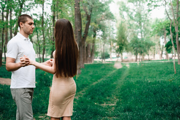 Nice outdorr portrait of young beautiful couple in love with green background