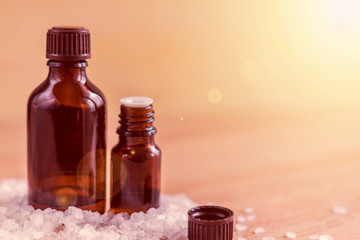 two brown bottle for essential oil in sea salt, aromatherapy and spa concept with copy space