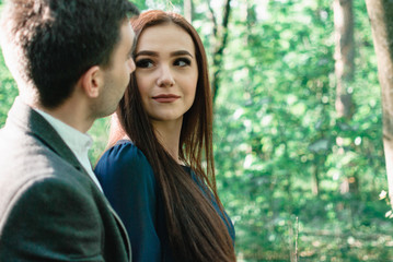 Nice outdorr portrait of young beautiful couple in love with green background