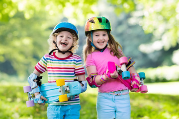 Children riding skateboard in summer park © famveldman