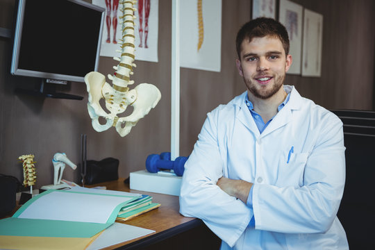 Portrait of physiotherapist sitting at his desk