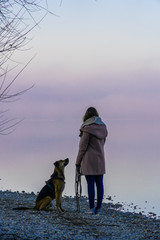 A girl with her dog at sunrise - 200136618