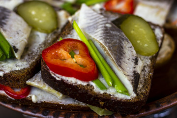Sandwich with herring, marinated cucumber, onion and pepper