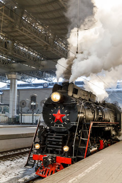 old black steam locomotive in Russia in the winter on the background of the Moscow railway station