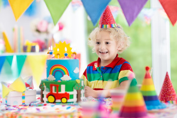 Kids birthday party. Child blowing out cake candle