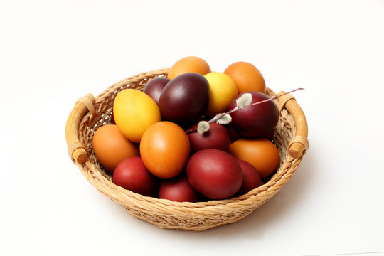 red and yellow Easter eggs in basket on white background