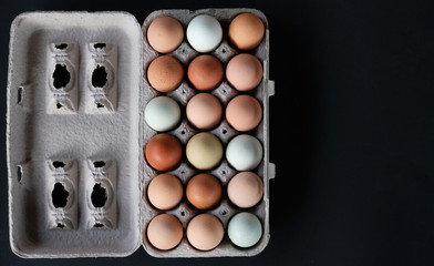 Flat lay of eggs in brown carton, great for fresh natural food print or graphic.