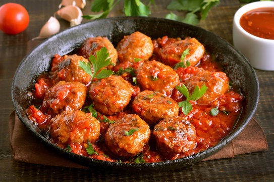 Meatballs with parsley in cast iron pan
