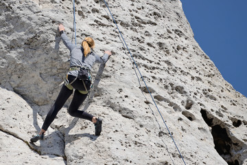 A woman climbing the rocks.