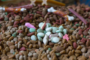 Vitamin tablets for pets on hip of dry pet food.