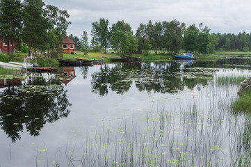 Motor boats and a small house on the shore of the lake