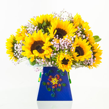 A bouquet of fresh sunflowers in a hand-decorated cardboard box. Decorative quiling on a box.