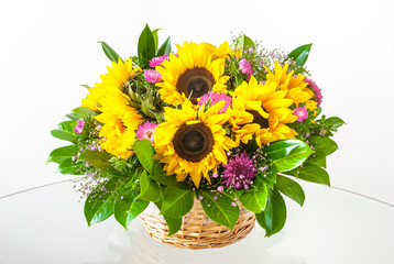 Beautiful fresh sunflowers in a basket on a white background.