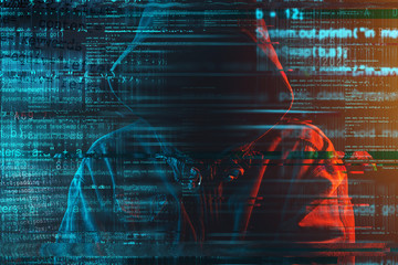 Stereotypical image of computer hacker with hoodie and computer code