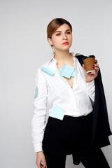 portrait of a girl in a business suit and a white shirt holding a glass of coffee and wrapped the entire paper blue sticker on a white background
