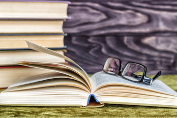 Stacks of colored books on a wooden table. concept of reading habits