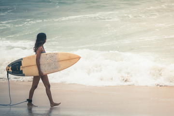 Surfer with surfboard gonna to surf spot, walk near beach.