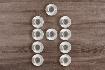 Set of coffee cups in the form of letter A on wooden background