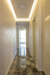 new home corridor with an open door at the end and ceramic tiles