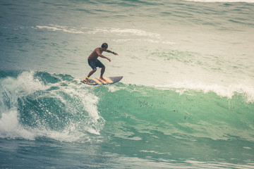 Surfer on Blue Ocean Wave, Bali, Indonesia. Riding in tube.