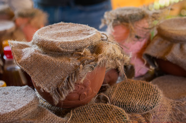 Honey in ceramic pot. Organic produce for sale at market.