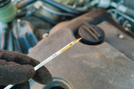 checking the oil level in a car engine