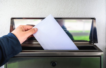 hand putting mail in mailbox