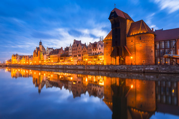 Fototapeta na wymiar Historic port crane in Gdansk reflected in Motlawa river at dusk, Poland
