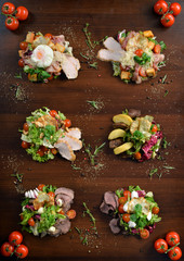 Fresh salad with chicken, tomatoes and mixed greens arugula, mesclun, mache on wooden background...