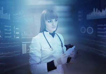 Innovative technologies in science and medicine. Beautiful female doctor and virtual display controls